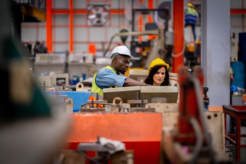two employees in warehouse using it solutions for manufacturing