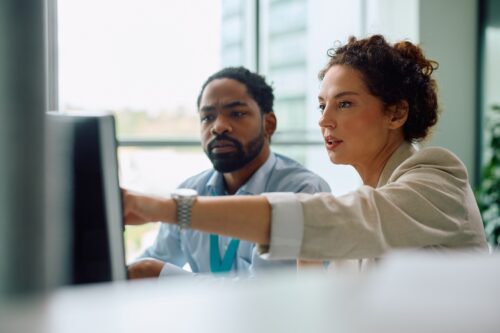 coworkers working on computer in office